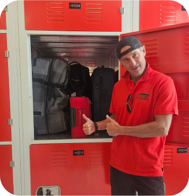 Individual posing next to red storage lockers filled with bags and a red container.