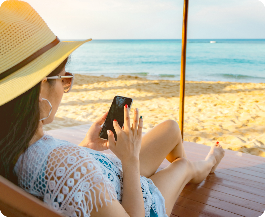 lady browsing on phone on a beach