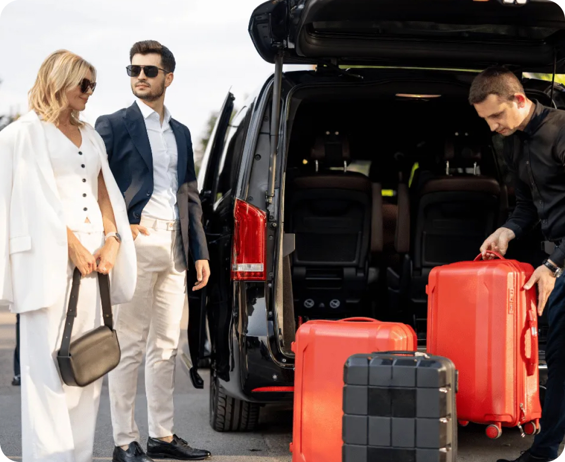Valet picking up luggage and 2 customers standing besides him