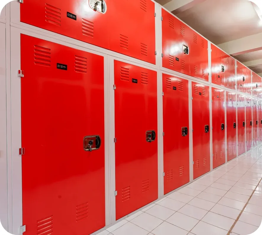 Interior view of a storage unit facility featuring red doors along half hallway.